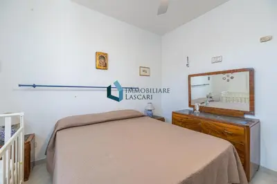 a bedroom with a bed and a mirror at Villa Limuti con piscina condominiale in Campofelice di Roccella