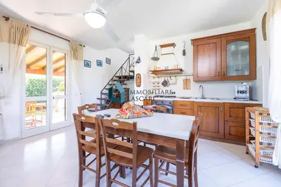 a kitchen with a dining room table and chairs at Villa Limuti con piscina condominiale in Campofelice di Roccella