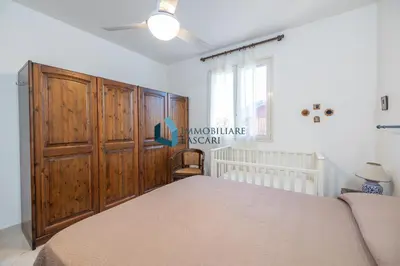 a bedroom with a bed and a large wooden closet at Villa Limuti con piscina condominiale in Campofelice di Roccella