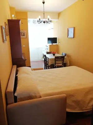 a bedroom with a bed and a dining room with a table at Oreto Bridge in Palermo