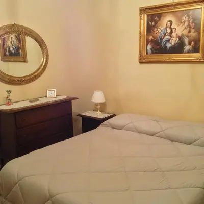 a bedroom with a bed and a mirror and a painting at Oreto Bridge in Palermo