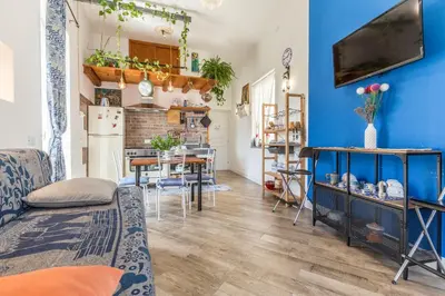 a living room with a blue wall and a kitchen at Gò Gò House 2 Casa Aprile in Palermo
