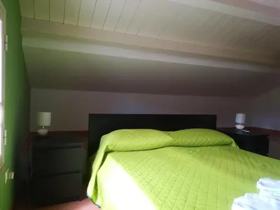 a bedroom with a green bed with two night stands at Villa Mimmo in Lascari