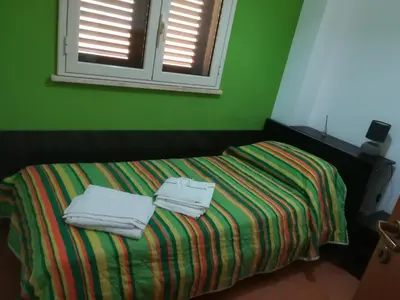 a green bedroom with a bed with towels on it at Villa Mimmo in Lascari