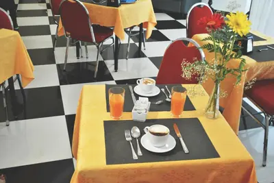 a table with a plate of food and a cup of coffee at Hotel Columbia in Palermo