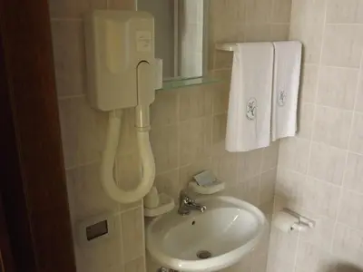a bathroom with a sink and a phone on the wall at Hotel Columbia in Palermo