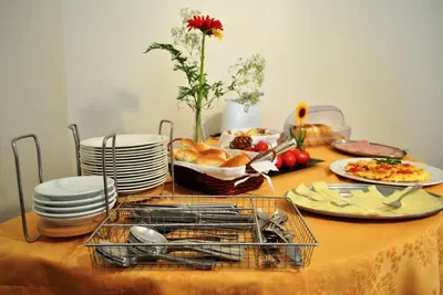 a table with plates of food and a basket of bread at Hotel Columbia in Palermo