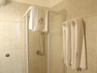 a bathroom with a shower with white towels at Hotel Columbia in Palermo