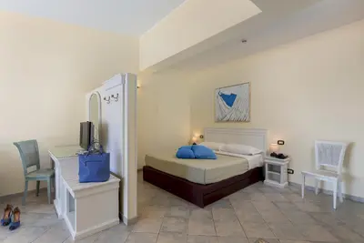 a living room with a couch and a view of the ocean at Hotel Riviera in San Vito lo Capo