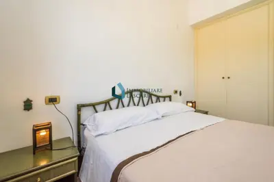 a bedroom with a large white bed and a dresser at Villa Nettuno con piscina privata in Campofelice di Roccella