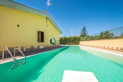 an empty swimming pool next to a building at Villa Nettuno con piscina privata in Campofelice di Roccella