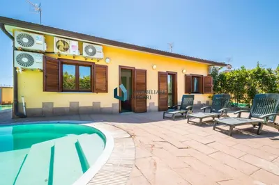 a house with a swimming pool in front of it at Villa Nettuno con piscina privata in Campofelice di Roccella