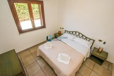 a bedroom with a large bed with two towels on it at Villa Nettuno con piscina privata in Campofelice di Roccella