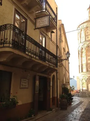 a building with a balcony on a street at Locanda Re Ruggero in Monreale