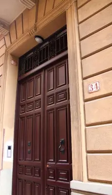 a large wooden door on the side of a building at Re Federico Apartment in Palermo