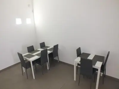 a dining room with two tables and black and white chairs at Re Federico Apartment in Palermo
