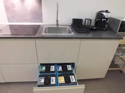 a kitchen counter with a sink and a box with remote controls at Re Federico Apartment in Palermo