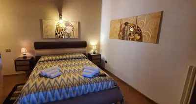 a bedroom with a bed and two pictures on the wall at 25min da Cefalù e Palermo Piscina pvt, 4camere, 150m dal mare in Trabia