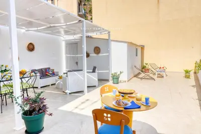 a patio with a table and chairs in a building at Casa dei Coralli Panoramic Sea View Centro Storico By Sicily Home Solutions in Castellammare del Golfo
