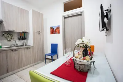 a kitchen with a table with a basket of food and wine glasses at Casa Florio Appartamenti in Palermo