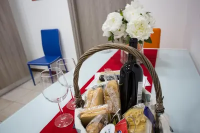 a basket of food and wine on a table with a glass at Casa Florio Appartamenti in Palermo