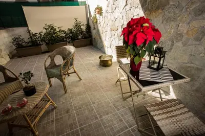 a table with a vase of red flowers on it at Casa Florio Appartamenti in Palermo