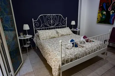 a bedroom with a bed and two tables with lamps at Casa Florio Appartamenti in Palermo