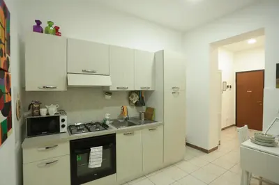 a kitchen with white cabinets and a stove top oven at Casa Florio Appartamenti in Palermo