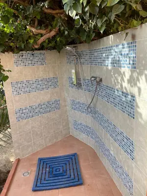 a bathroom with a shower with blue tiles at Villa Hibiscus Scopello in Scopello