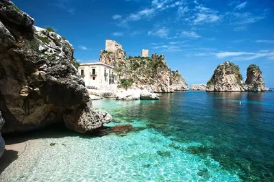 a view of a beach with rocks and the water at Villa Hibiscus Scopello in Scopello