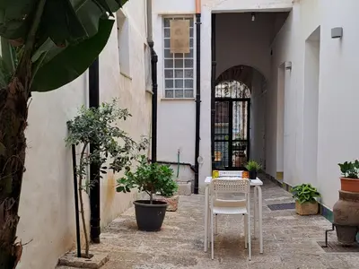 an alley with a table and a chair in a building at Affittacamere Garibaldi in Alcamo
