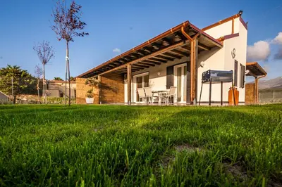 a house with a green lawn in front of it at Villa Barbara...a 100 passi dal mare!!!! in Lascari