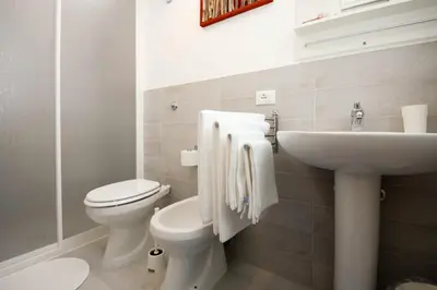 a bathroom with a white toilet and a sink at Villa Barbara...a 100 passi dal mare!!!! in Lascari