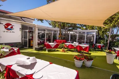 an outdoor patio with tables and chairs and a building at Villa Pasquale...immersa nella tranquillita' in Lascari