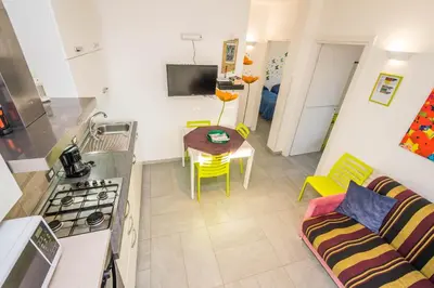 a kitchen and living room with a couch and a table at Villa Francesco...graziosa, moderna, confortevole! in Lascari
