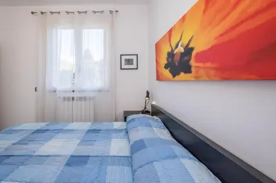 a bedroom with a bed and a painting on the wall at Villa Francesco...graziosa, moderna, confortevole! in Lascari