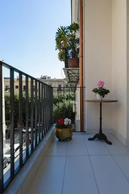 a balcony with a table and potted plants on it at Ai Bastioni del Massimo in Palermo