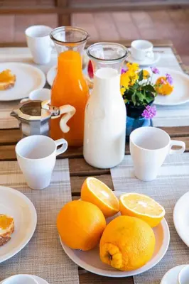 a table with plates of oranges and bottles of milk at Riva Sea Apartments in Castellammare del Golfo