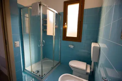 a bathroom with a toilet and a glass shower at Riva Sea Apartments in Castellammare del Golfo