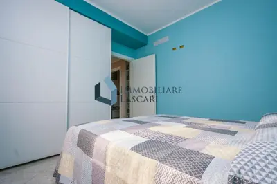 a bedroom with a bed and a blue wall at Villa Ricky, a pochi passi dal mare in Lascari