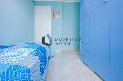 a blue bedroom with a bed and a cabinet at Villa Ricky, a pochi passi dal mare in Lascari