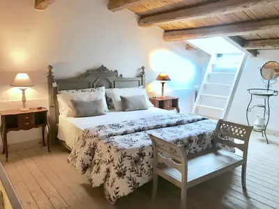 a bedroom with a large bed and two chairs at Casa Vigliena in Palermo
