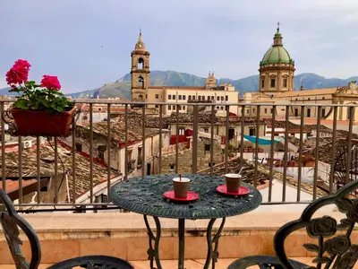 a table on a balcony with two cups of coffee at Casa Vigliena in Palermo