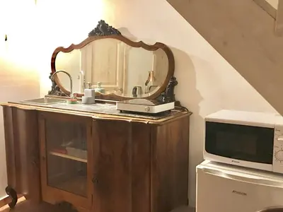 a mirror on top of a dresser next to a microwave at Casa Vigliena in Palermo