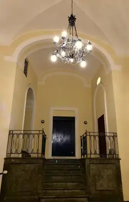 a chandelier in a large building with stairs at Casa Vigliena in Palermo