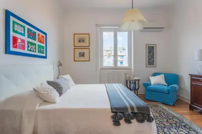a bedroom with a bed and a blue chair at Luxury Apartment * Immo's House* in Palermo