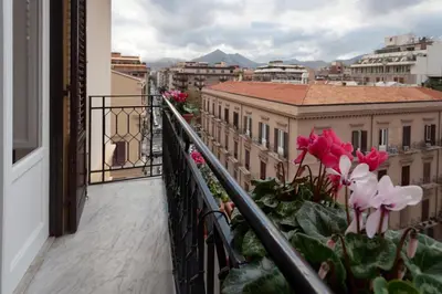 a balcony with pink flowers on a building at Luxury Apartment * Immo's House* in Palermo