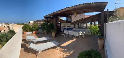 a patio with a table and chairs and a pavilion at Blu Terrace in San Vito lo Capo