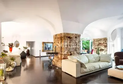 a living room with a white couch and a stone wall at Atmosfere Puniche b&b in Palermo