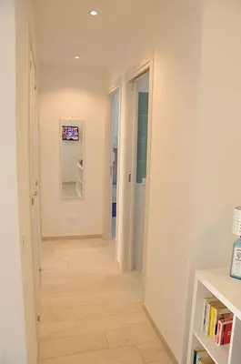 a hallway with white walls and a wooden floor at Appartamento Irma Dario in San Vito lo Capo